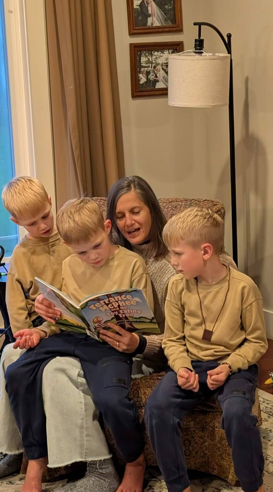 Mother reading Terrance McPhee to three young boys